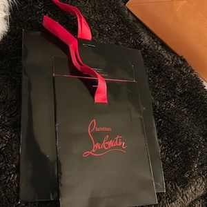 Two Louboutin shopping bags. There is a crease. No Damage